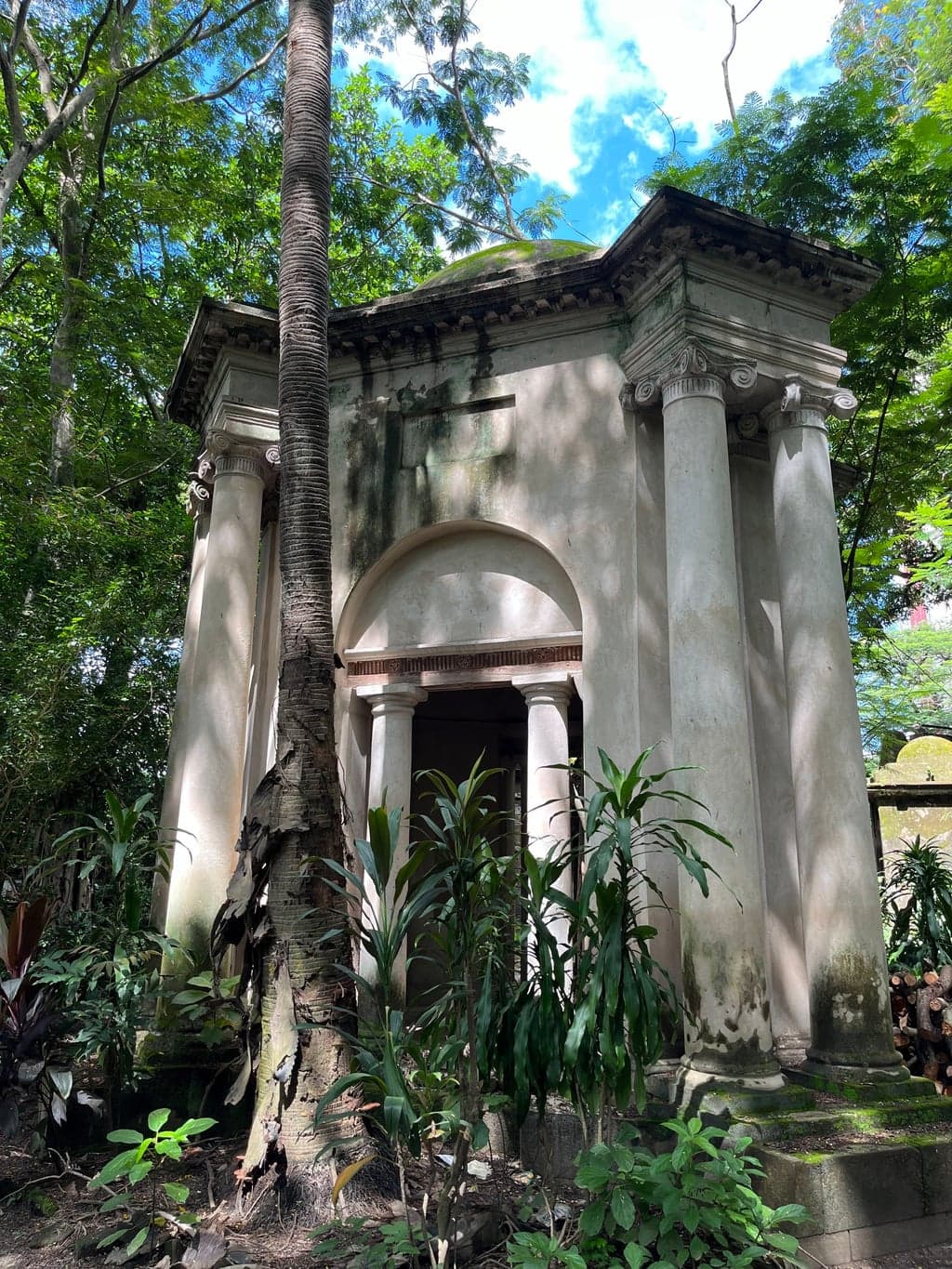 The round mausoleum — someone spent serious money on this. The tree growing beside the second is unimpressed.